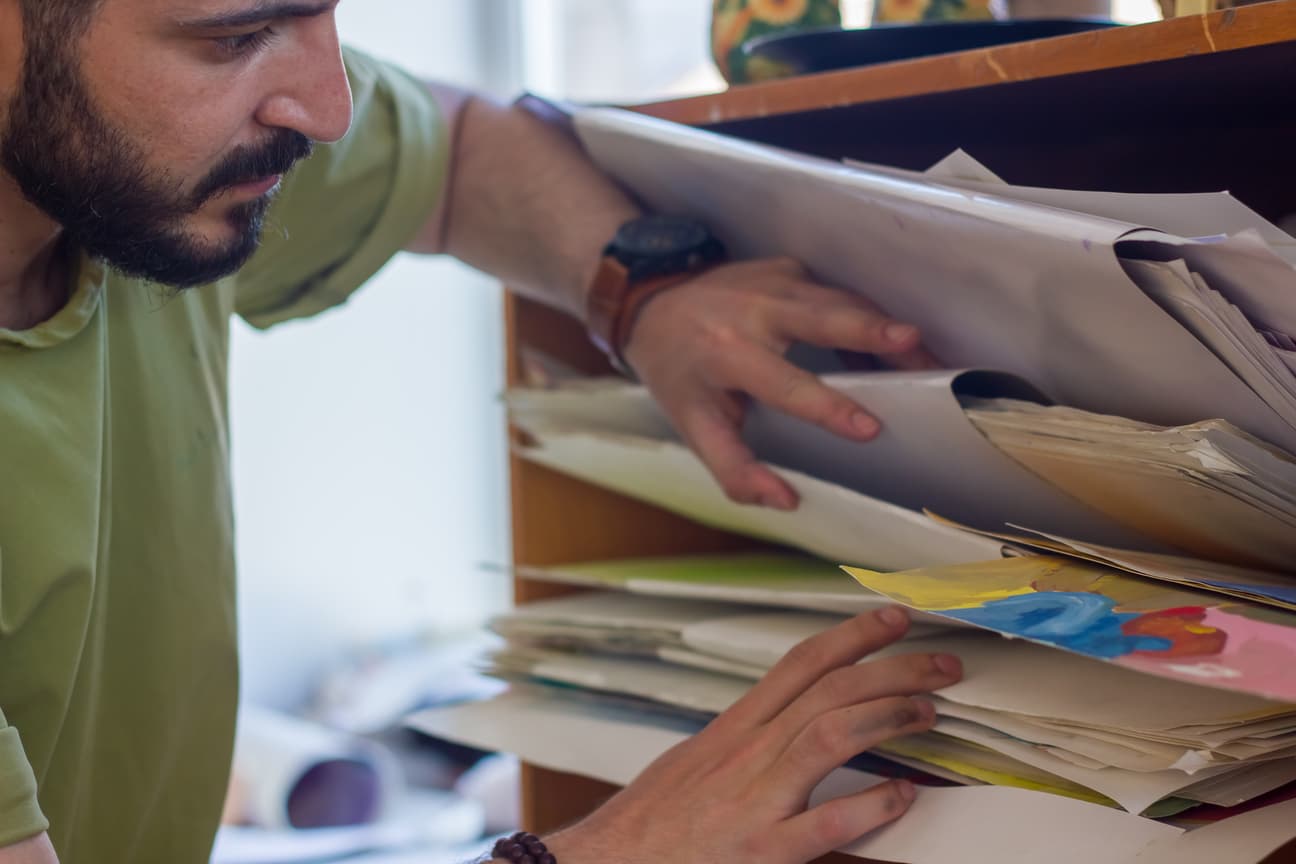 Persoană privind peste umăr la documente confidențiale